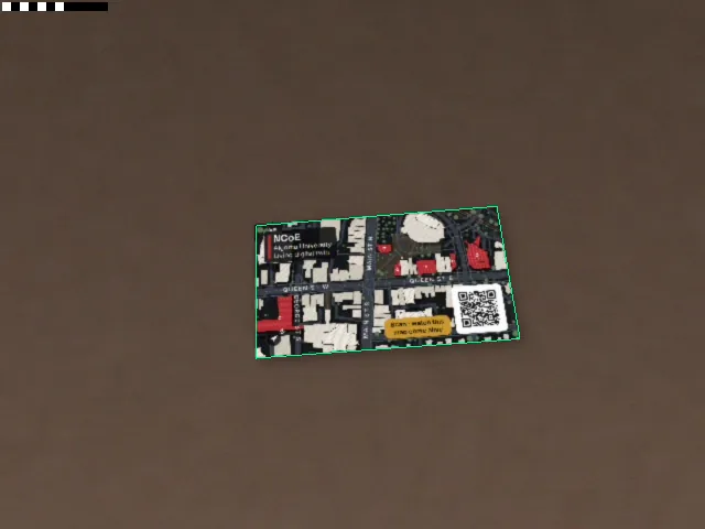 Tracking test: the card's map side lying on a brown table, outlined in green where the app has found it.
